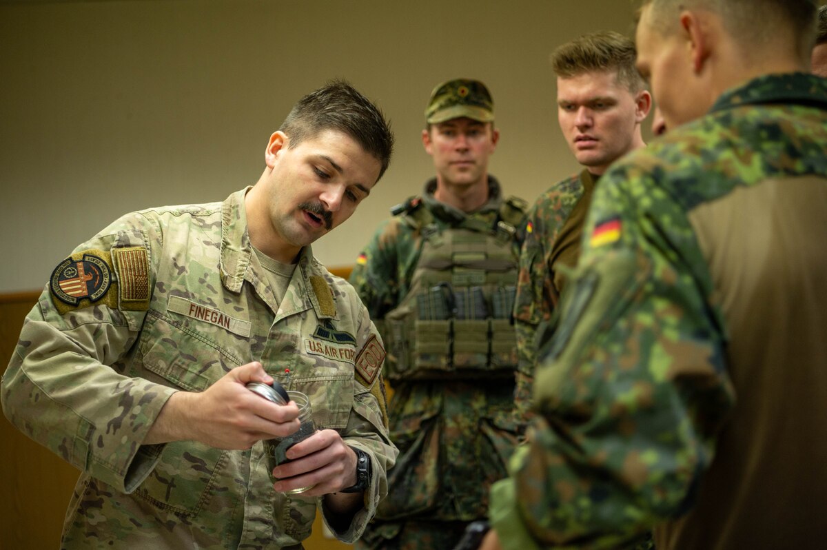 A U.S. Air Force Airman shows a device to German soldiers.
