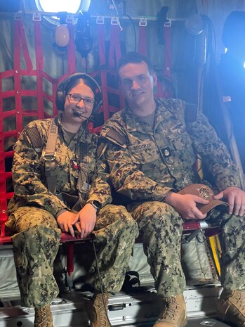 Navy Intelligence Specialist 1st Class Petty Officer sits with her partner of four years, ISC (Chief/E-7) Andrew Brooker, also a Reserve Sailor, aboard the U.S. Navy Blue Angels’ iconic “Fat Albert” C-130 as Redsicker prepares to reenlist during a mid-flight ceremony