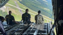 Navy Intelligence Specialist 1st Class Petty Officer sits with members of the U.S. Navy Blue Angels flight crew at the edge of the iconic “Fat Albert” C-130 following her reenlistment ceremony
