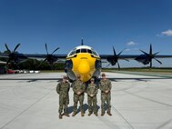 Navy personnel pose in front of the U.S. Navy Blue Angels’ iconic “Fat Albert” C-130 for a photo.
