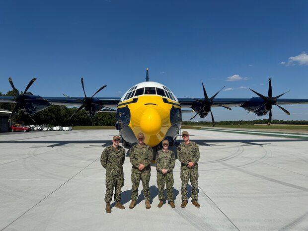 Navy personnel pose in front of the U.S. Navy Blue Angels’ iconic “Fat Albert” C-130 for a photo.