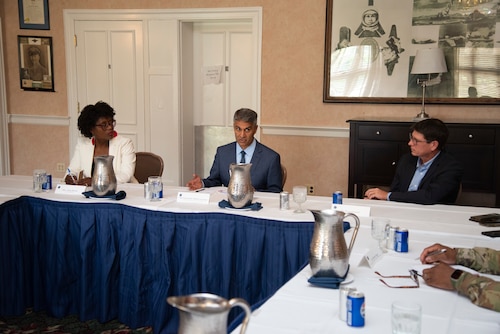 Three people at a table participating in a conversation.