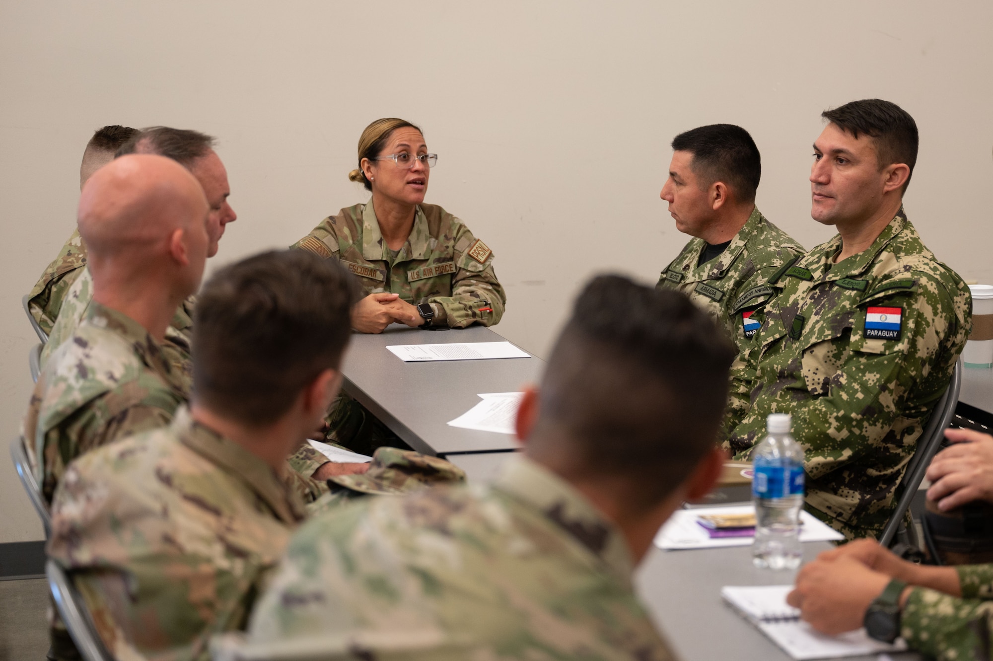 Massachusetts National Guardsmen sit at a table with members of the Paraguayan military.