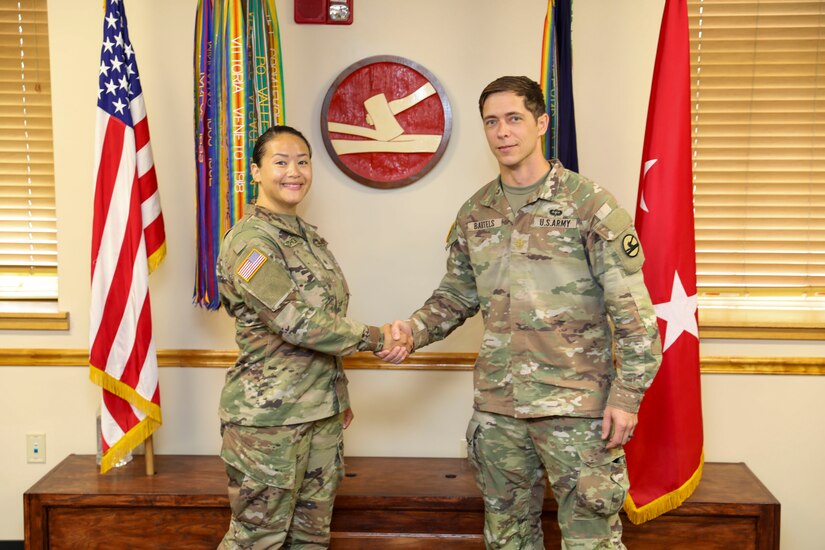 Army Maj. Christopher Bartels, Headquarters and Headquarters Detachment Commander for the 84th Training Command, shakes hands with Sgt. Sarah Choi, a Human Resource Specialist with the 84th Training Command, August 1, 2024 at Fort Knox, KY. Choi was promoted to the rank of Sergeant and plans to peruse a career as a warrant officer.