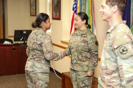 Army Sgt. 1st Class Madeline Martinez-Colon, acting 1st Sgt. for 84th Training Command Headquarters and Headquarters Detachment, shakes hands with Sgt. Sarah Choi, a Human Resource Specialist with the 84th Training Command at a promotion ceremony