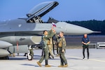 Two pilots high-five in front of an aircraft
