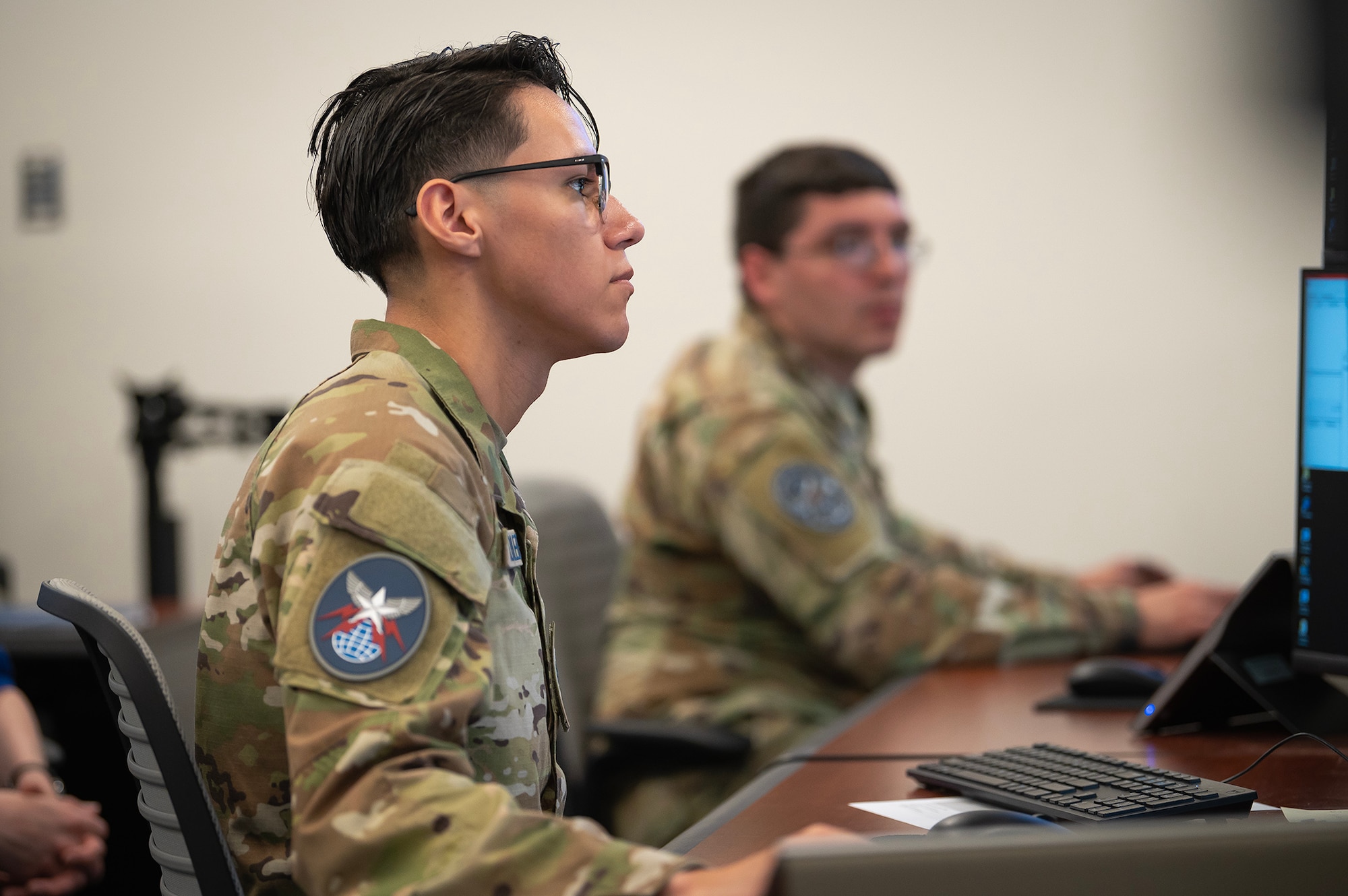 Two U.S. Space Force Guardians look at a computer monitor.