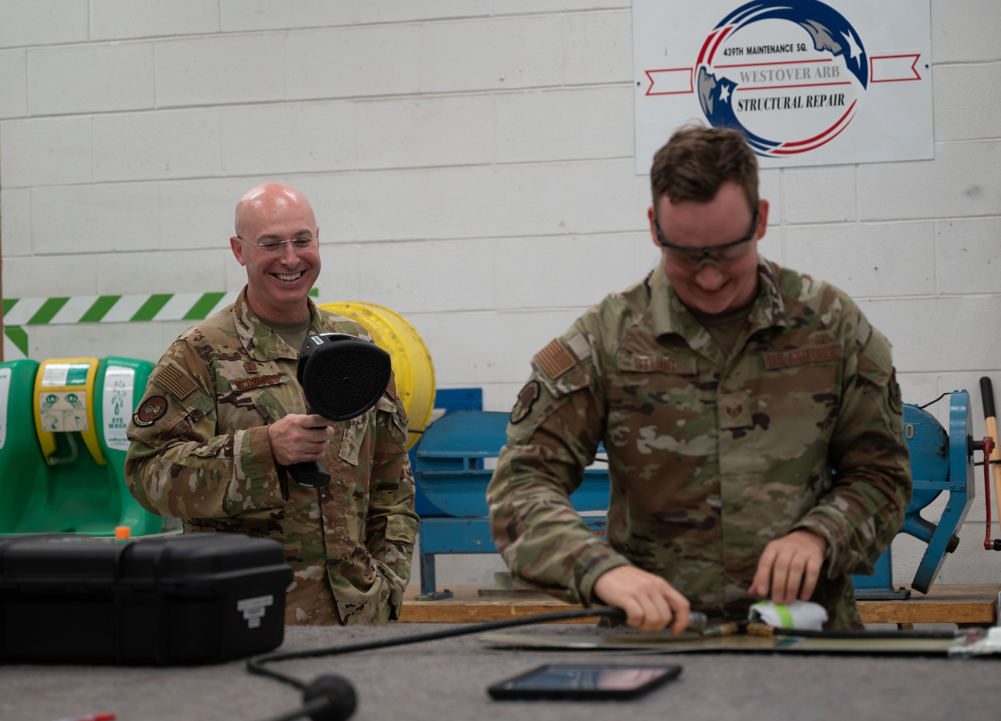 U.S. Air Force Col. Chris McDonald, left, 436th Airlift Wing commander, and Staff Sgt. Tyler Stuhr, 439th Maintenance Group aircraft structural craftsman, demonstrate the Forward-looking Infrared Acoustic Imaging Camera at Westover Air Reserve Base, Massachusetts, July 31, 2024. The camera is a newer piece of technology that the 439th MXG is using to aid in maintenance repairs. (U.S. Air Force photo by Airman Liberty Matthews)