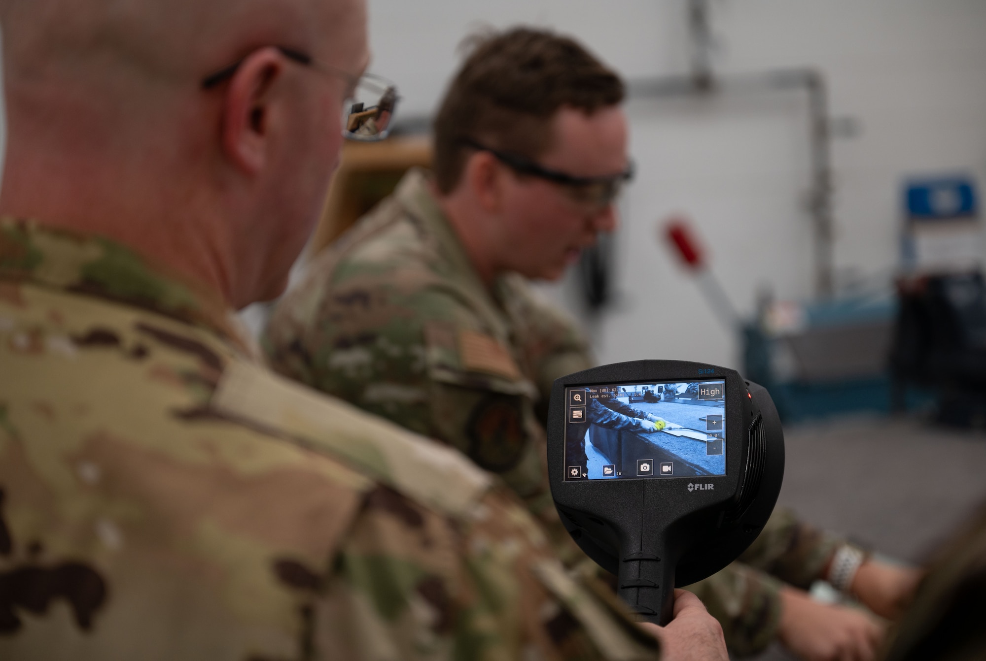 U.S. Air Force Col. Chris McDonald, left, 436th Airlift Wing commander, and Staff Sgt. Tyler Stuhr, 439th Maintenance Group aircraft structural craftsman, demonstrate a Forward-looking Infrared Acoustic Imaging Camera at Westover Air Reserve Base, Massachusetts, July 31, 2024. The camera is a newer piece of technology that the 439th MXG is using to aid in maintenance repairs. (U.S. Air Force photo by Airman Liberty Matthews)