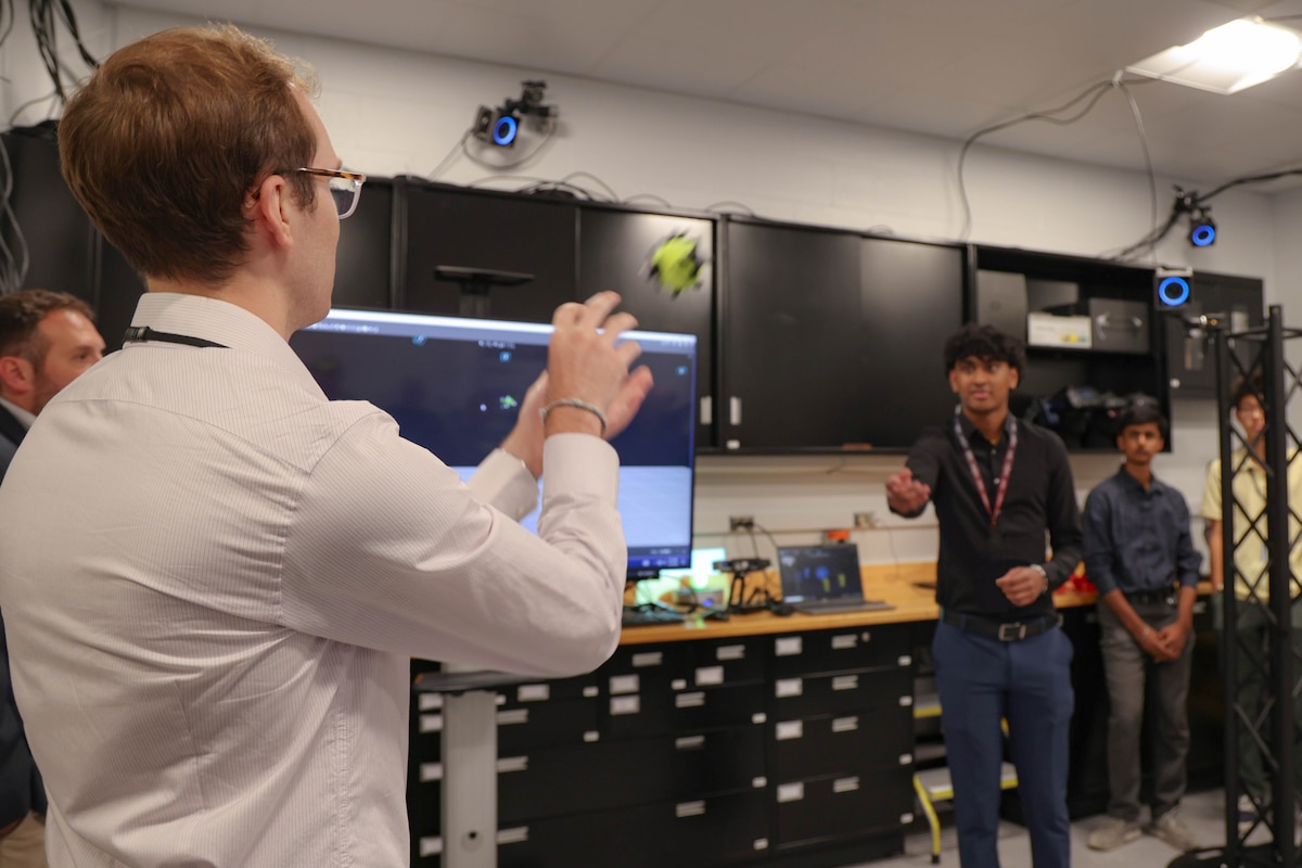From left: Andrew Bowman, on-site researcher with the Air Force Research Laboratory’s Digital Manufacturing Research Team, or DMRT, and Yash Kakade, a DMRT summer intern, demonstrate the motion capture system in the newly opened Collaborative Automation for Manufacturing Systems Laboratory at Wright-Patterson Air Force Base following a ribbon-cutting ceremony July 23, 2024. (U.S. Air Force photo / Sarah Perez)