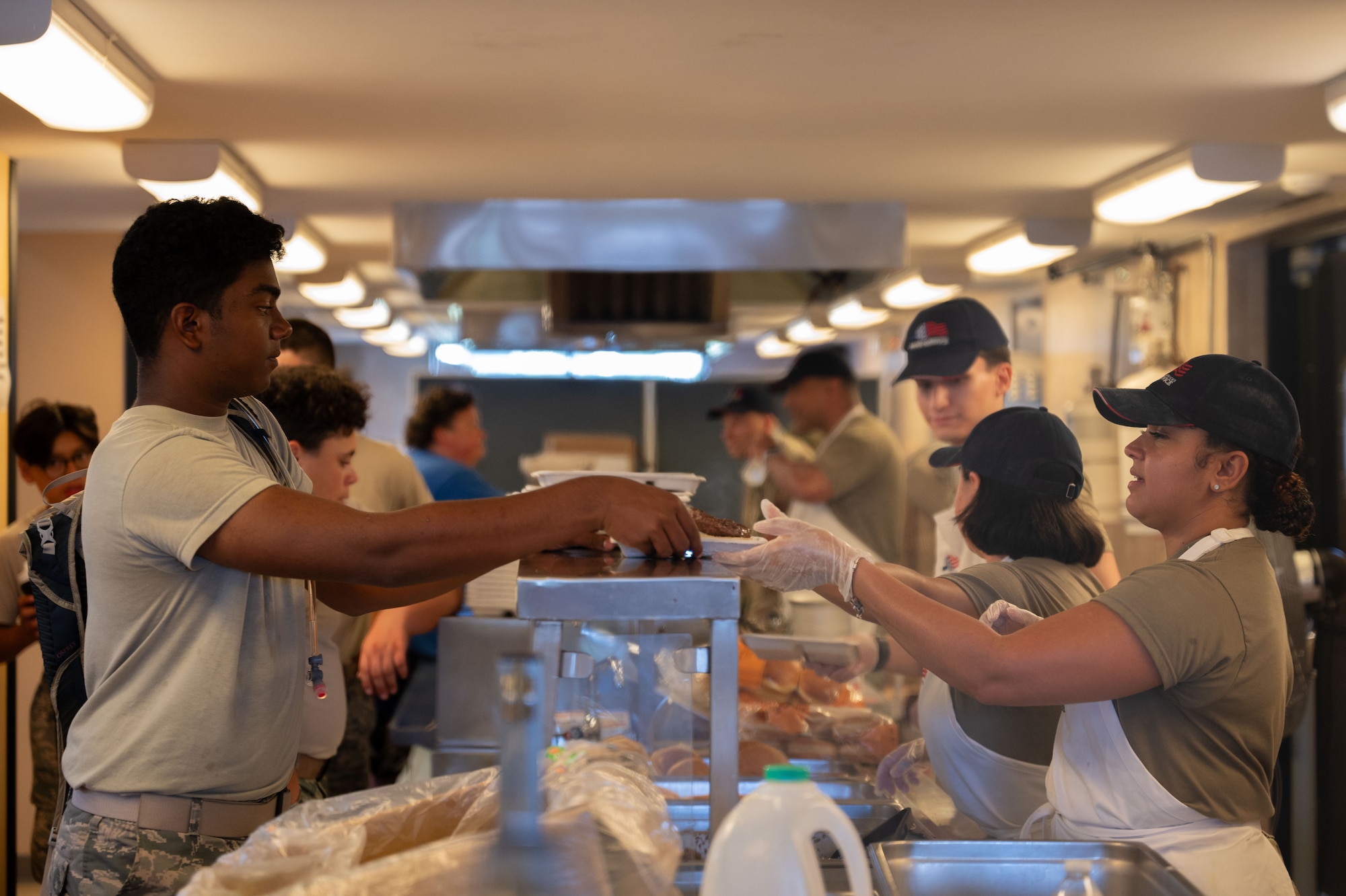 Airman serves food over counter.