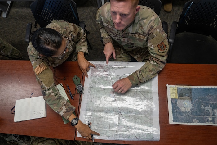 Airman study a map on a desk