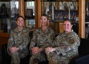Three women pose for a group photo.