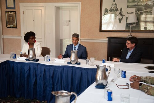Three people at a table participating in a conversation.