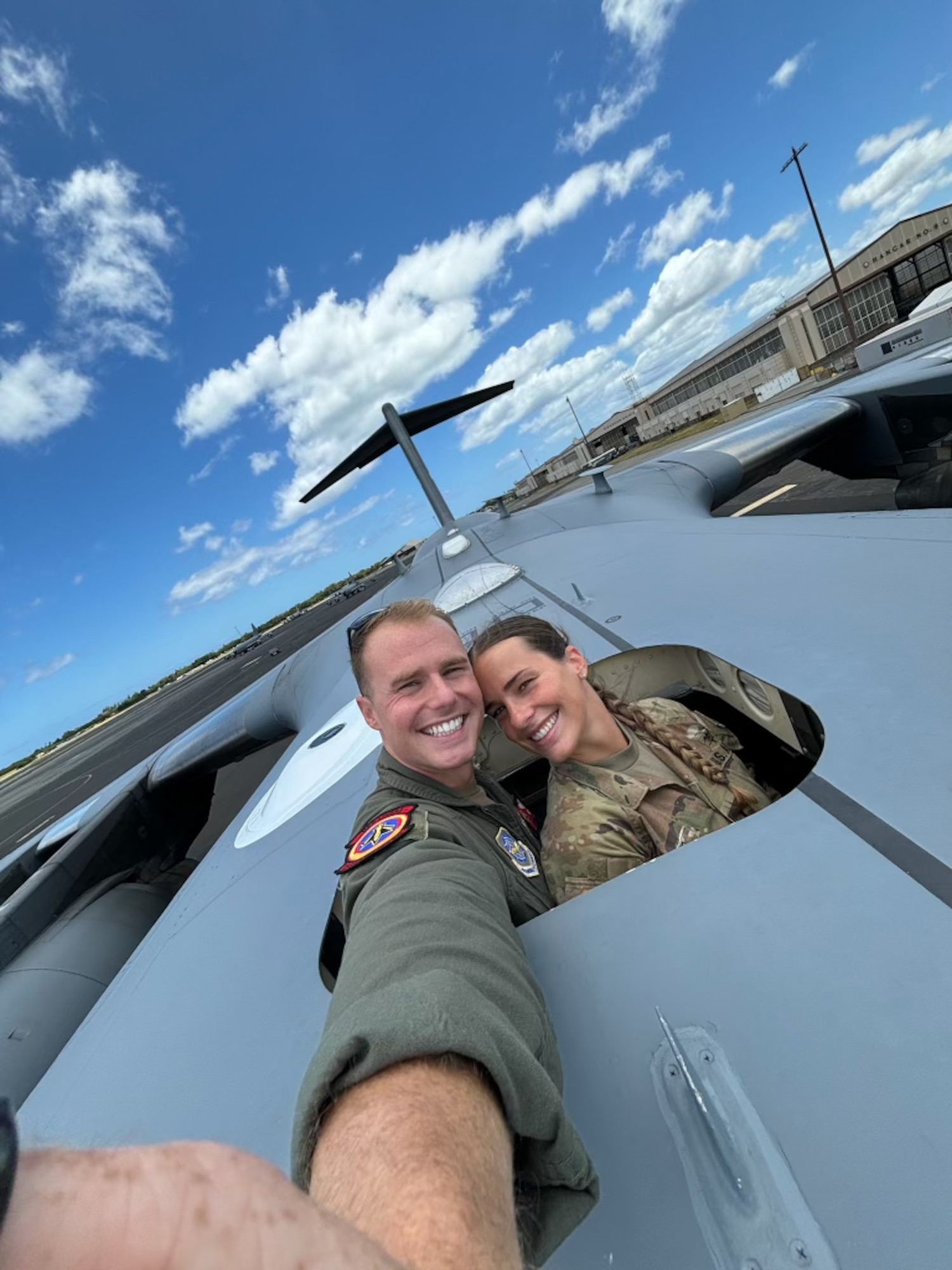 An Air Force Captain and an Army Lieutenant pose for a selfie on an aircraft