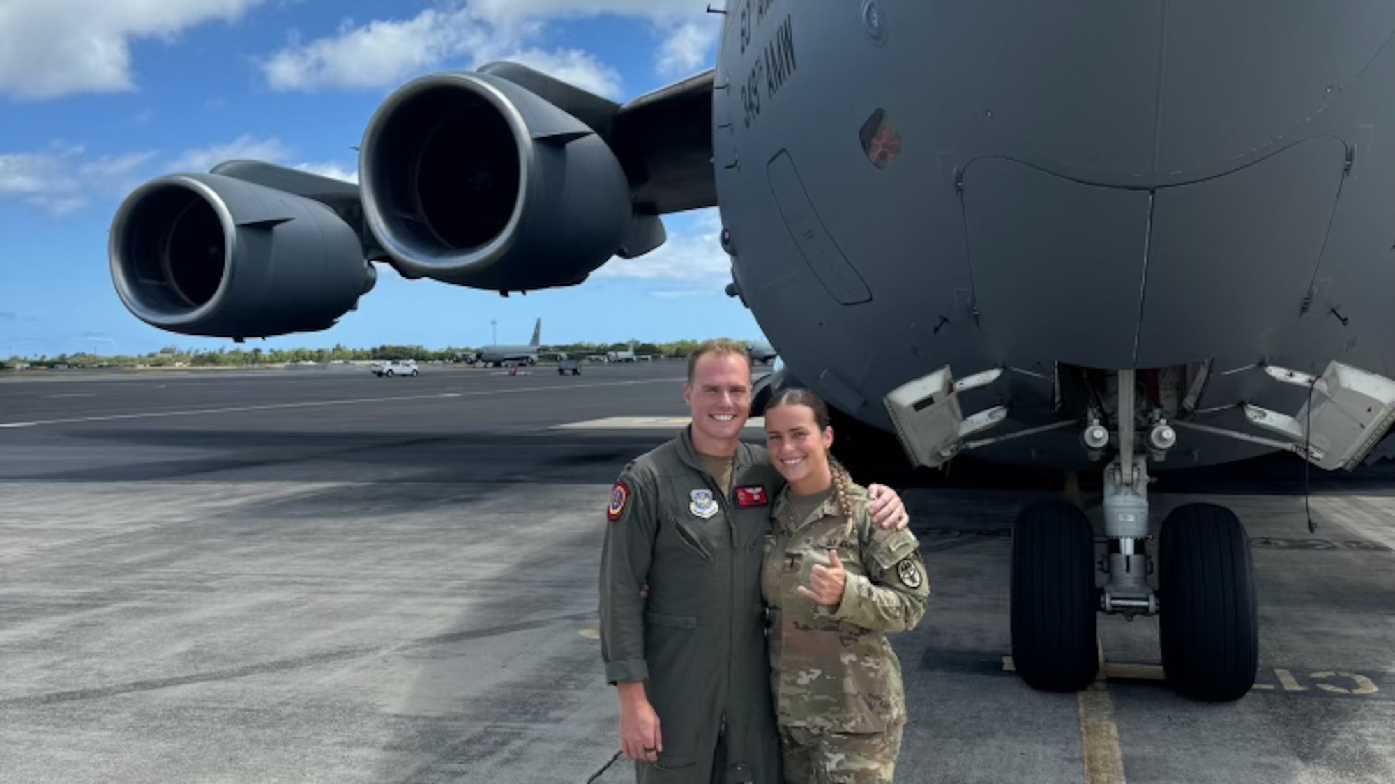 An Air Force Captain and an Army Lieutenant pose for a photo in front of an aircraft