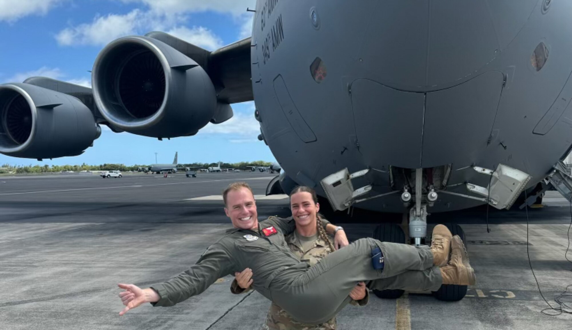 An Army nurse carries her Air Force pilot brother in her arms in front of an aircraft