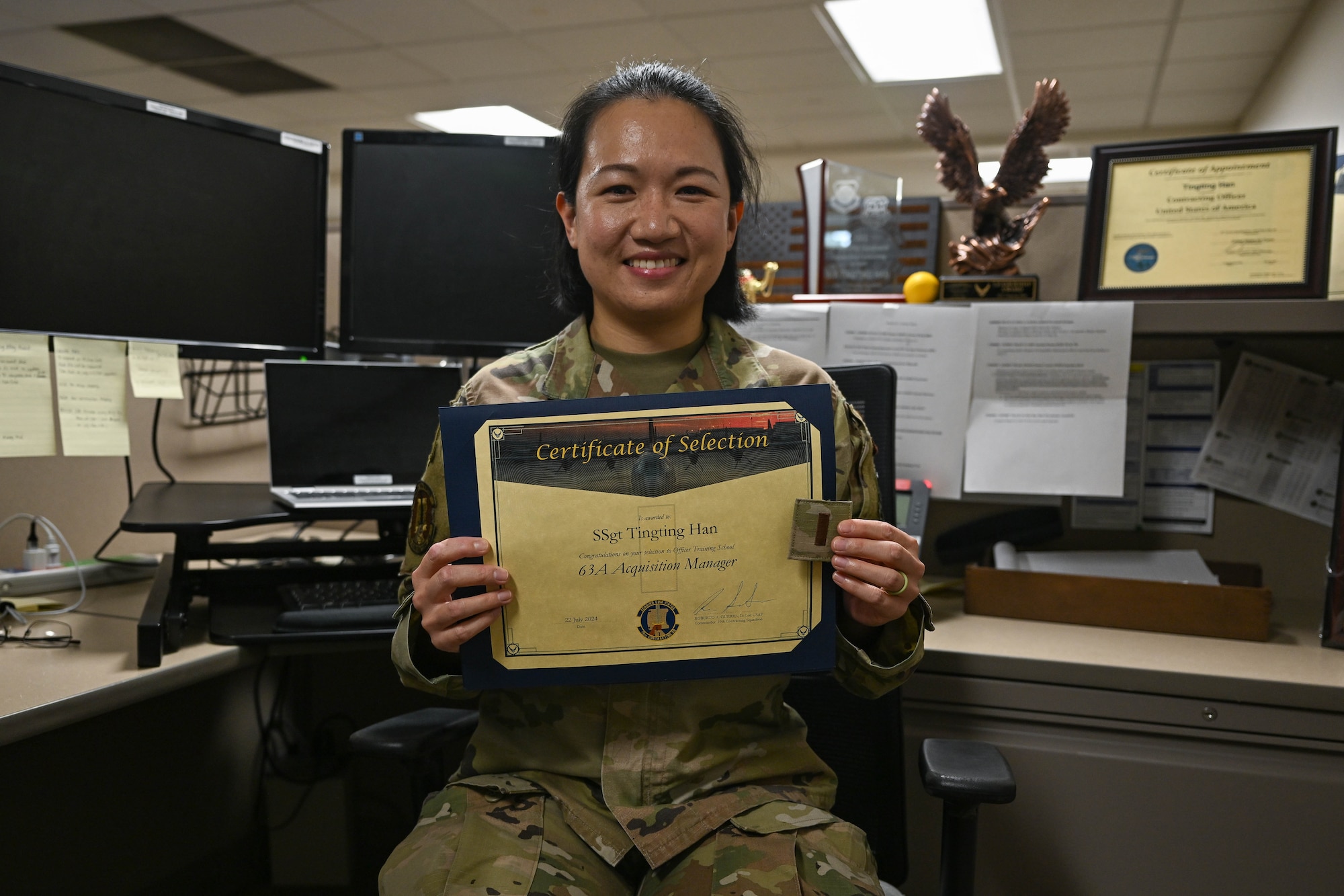 An Airman holds up a certificate.