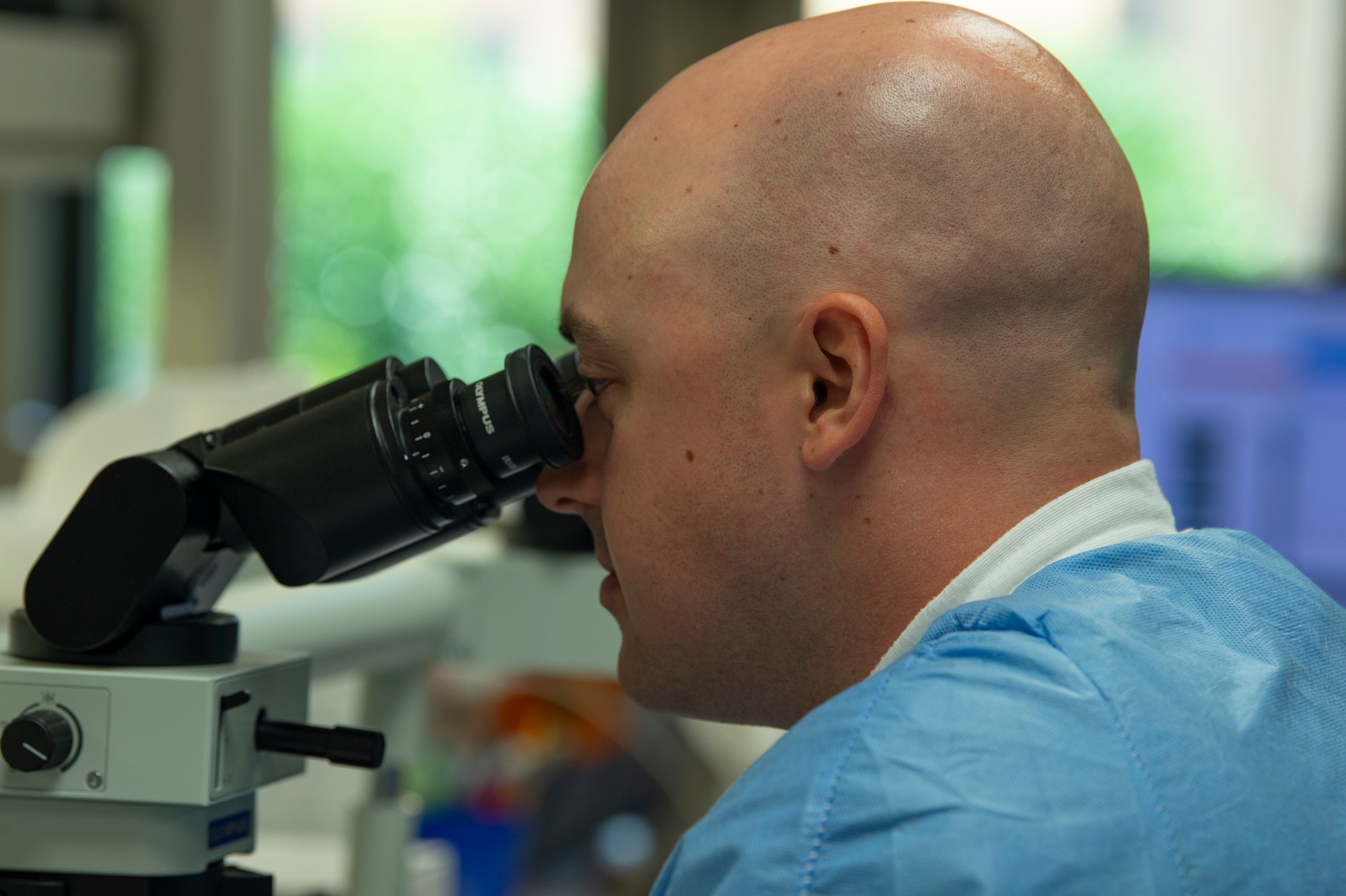 Someone looking through a microscope.