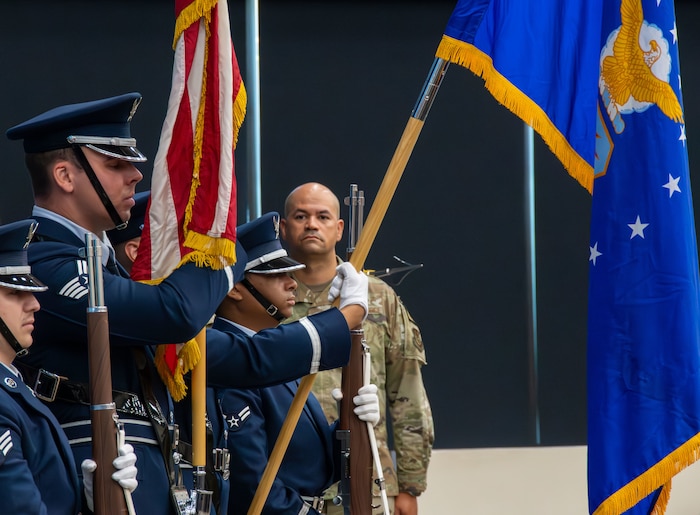 Col. Jason Harris, new AFSFC commander, stands behind the flags as they are presented