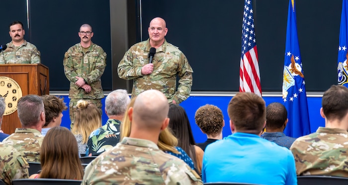 Col. Phillip Born stands up in front of audience and provides remarks