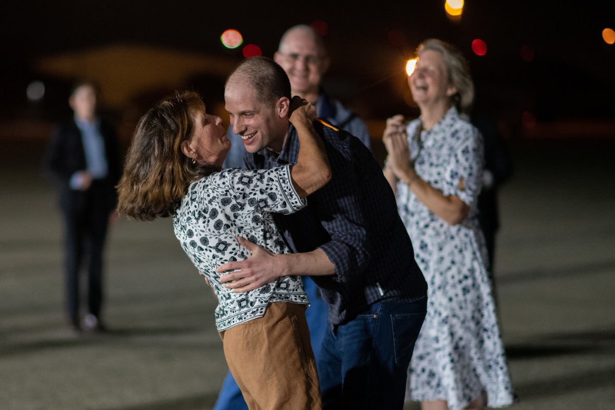 A man and woman hug.