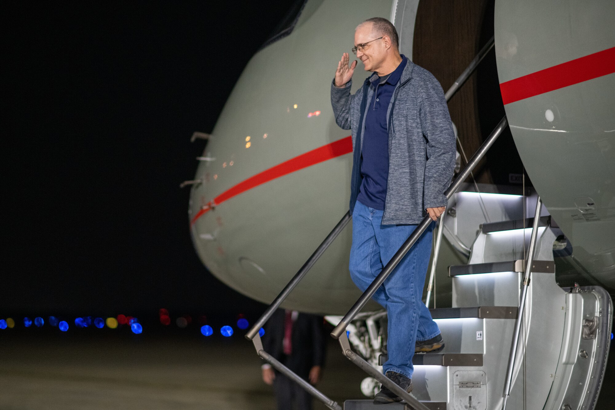 A man walks down a plane's stairway.