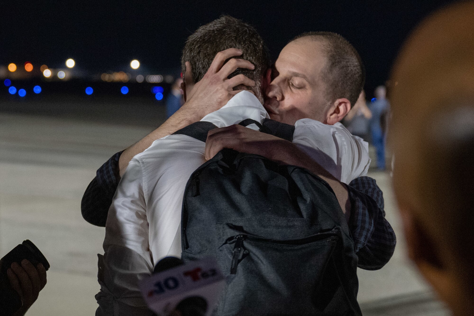 A man hugs another man.