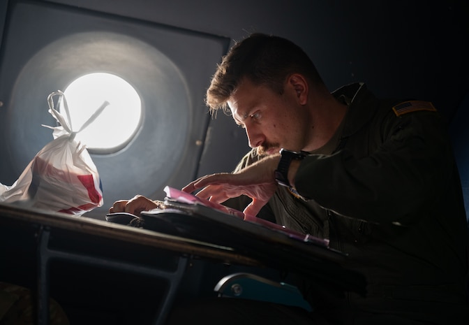 U.S. Air Force Capt. Jim Beidleman, 9th Airlift Squadron pilot, reviews maintenance forms before take off at Dover Air Force Base, Delaware, July 31, 2024. Beidleman was the aircraft commander for the flight to Westover Air Reserve Base. (U.S. Air Force photo by Airman Liberty Matthews)
