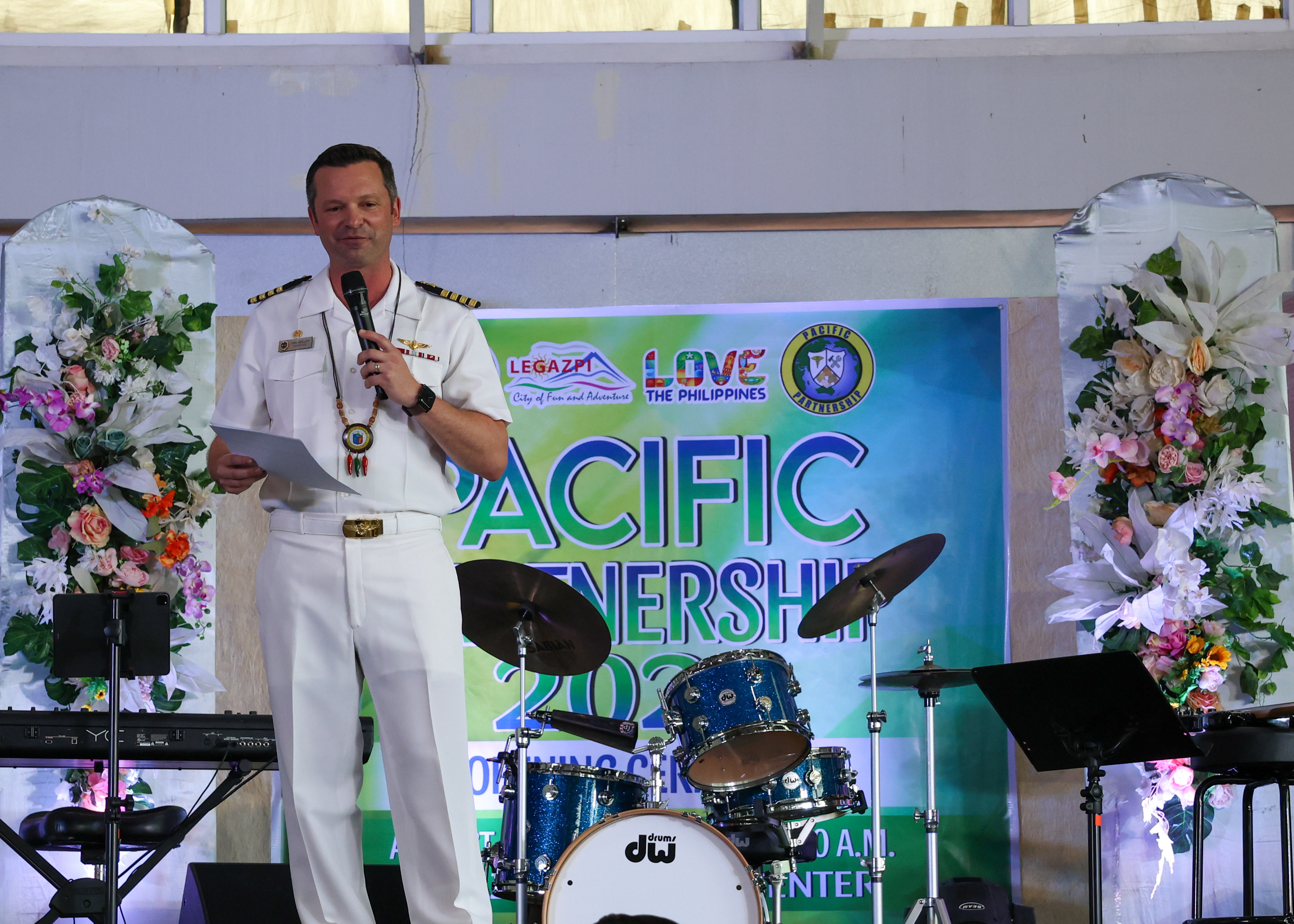 LEGAZPI, Philippines (Aug. 2, 2024.) - U.S. Navy Capt. Daniel Keeler, the Pacific Partnership 2024-2 (PP24-2) mission commander, delivers remarks during the PP24-2 opening ceremony at the Legazpi Expo Center in Legazpi, Philippines, Aug. 2, 2024. During this mission stop, U.S. servicemembers will work with the ally and partner nations of Australia, U.K. Singapore, the Republic of Korea and the Philippines, to Forster multilateral cooperation focusing on four lines of effort; humanitarian assistance and disaster relief, host nation outreach events, engineering and medical. Now in its 20th iteration, the Pacific Partnership series is the largest annual multinational humanitarian assistance and disaster relief preparedness mission conducted in the Indo-Pacific. Pacific Partnership works collaboratively with host and partner nations to enhance regional interoperability and disaster response capabilities, increase security and stability in the region, and foster new and enduring friendships in the Indo-Pacific. (U.S. Navy photo by Mass Communication Specialist Seaman Gavin Arnoldhendershot)