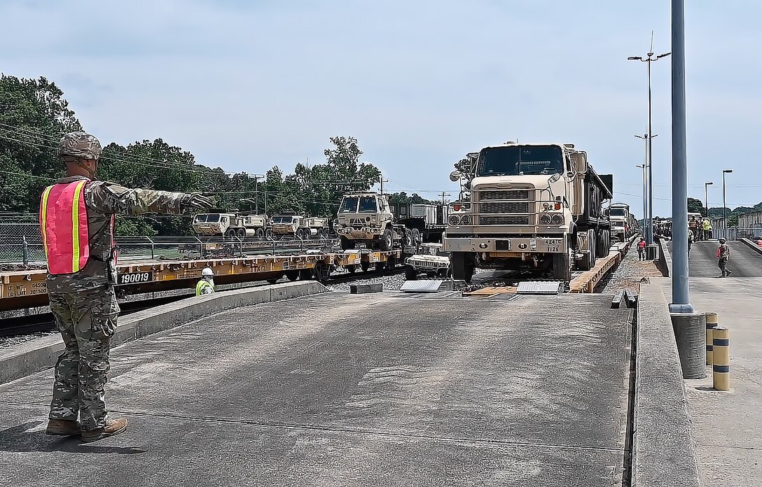 A Soldier directs a truck driving off a ramp