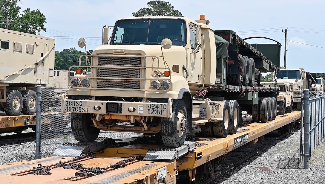 A Soldier drives a truck across a rail cart