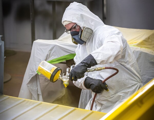 Chris Gaden, painter/blaster, Shop 71, Painters, Blasters and Tile Setters, sprays the bed of a Tiger mini-truck with a base coat of yellow paint July 25, 2024, during a project for Code 710, Special Projects at Puget Sound Naval Shipyard & Intermediate Maintenance Facility in Bremerton, Washington. (U.S. Navy photo by Jeb Fach)