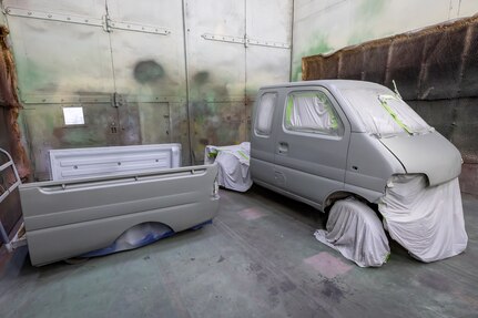 An old Tiger mini-truck, belonging to Code 710, Special Projects, sits primed and ready for a base coat of yellow paint, July 25, 2024, inside Building 873 at Puget Sound Naval Shipyard & Intermediate Maintenance Facility in Bremerton, Washington. A team of Shop 71, Painters, Blasters and Tile Setters, took on the unique project as a fun training opportunity for some of the shop's less experienced painters. (U.S. Navy photo by Jeb Fach)