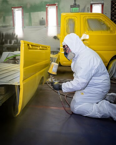 Bryan Harman, painter/blaster, Shop 71, Painters, Blasters and Tile Setters, spray paints the bed of a Tiger mini-truck July 25, 2024, during a special painting project for Code 710, Special Projects, inside Building 873 at Puget Sound Naval Shipyard & Intermediate Maintenance Facility in Bremerton, Washington. (U.S. Navy photo by Jeb Fach)