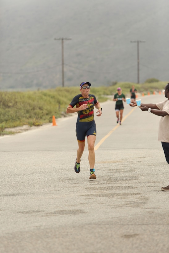 Col. Christine Houser, Marine Corps Air Station Camp Pendleton commander, stops for a water break during the 10K run, the final event of the 2024 Armed Forces Triathlon Championship on June 29. Houser finished second in the women's Master's Division, with a time of 2:24:49. During the 2023 Armed Forces Triathlon Championships Houser finished first in her age group and competed at the 2023 Conseil International du Sport Militaire (CISM) Military World Games in France.  (Dept. of Defense photo by Army Master Sgt. Sharilyn Wells)