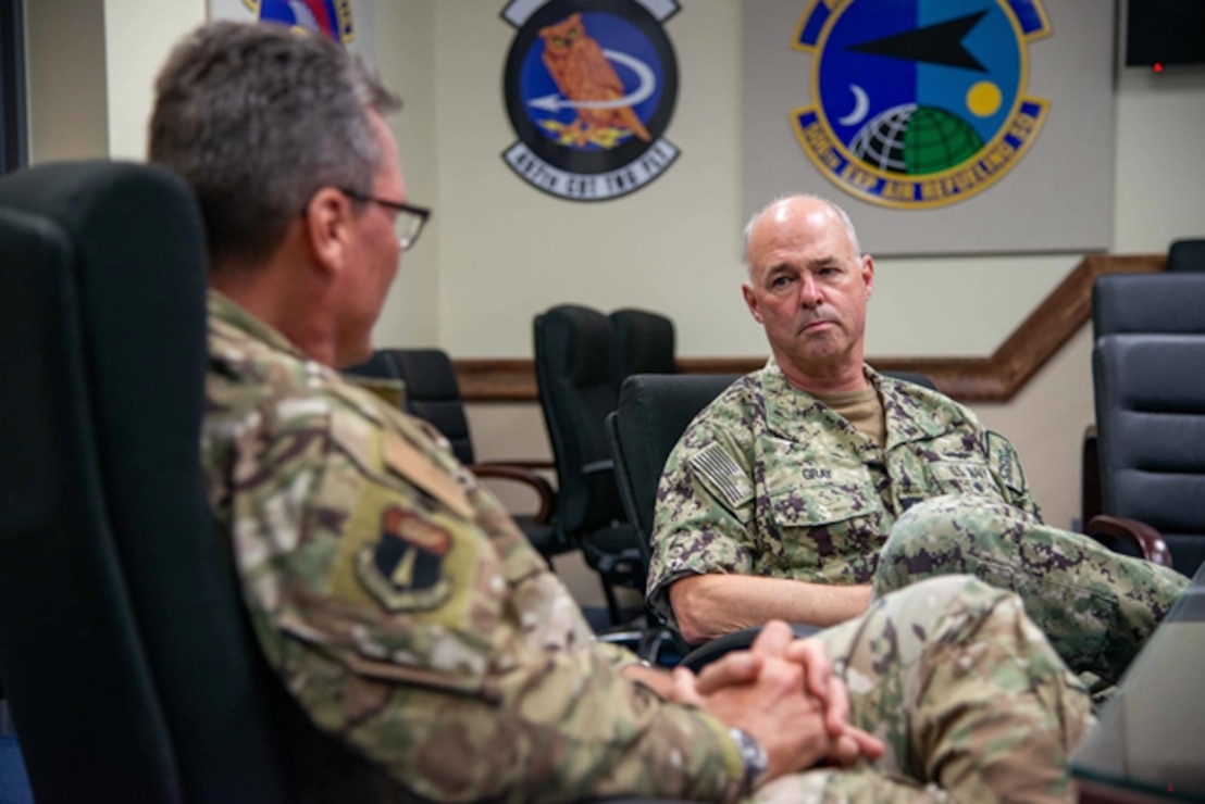 Commander, Navy Installations Command, speaks with U.S. Air Force Brig. Gen.