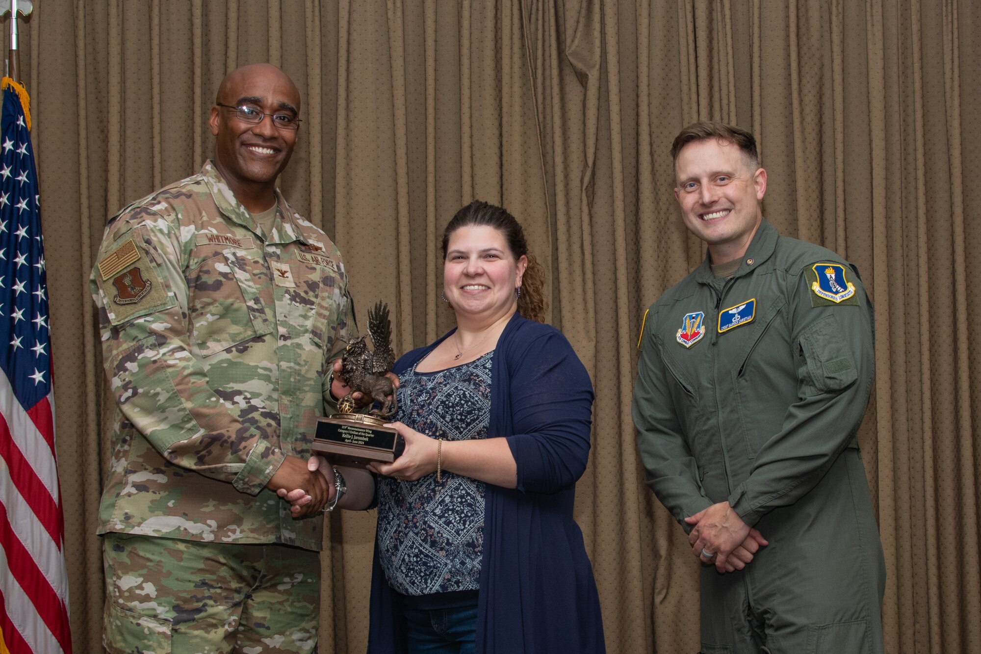 A military member stands on stage to accept an award.