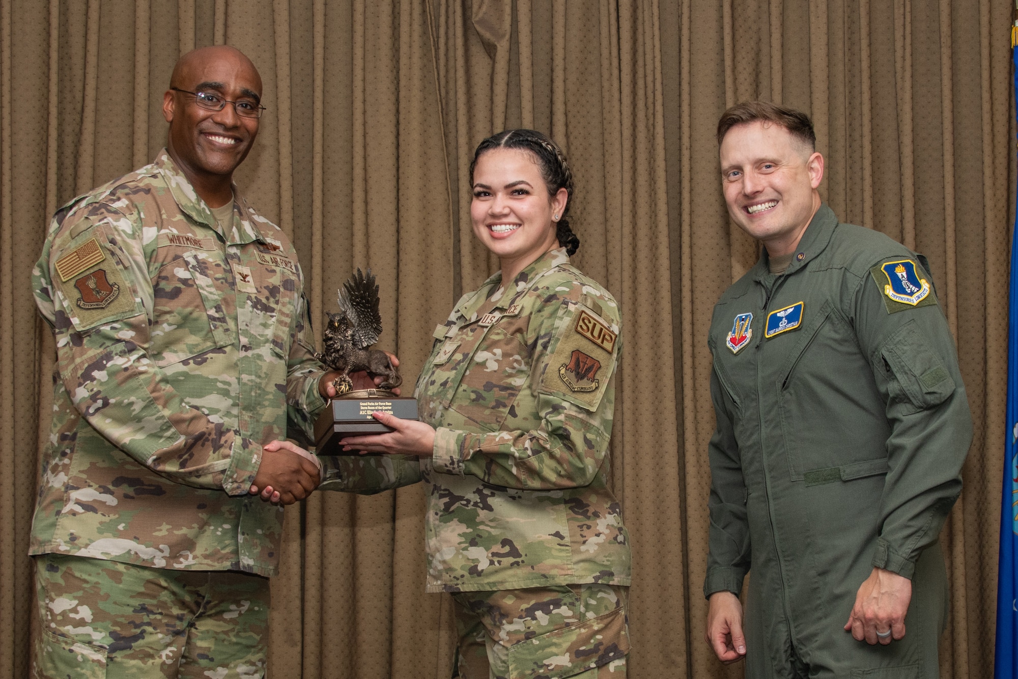 A military member stands on stage to accept an award.