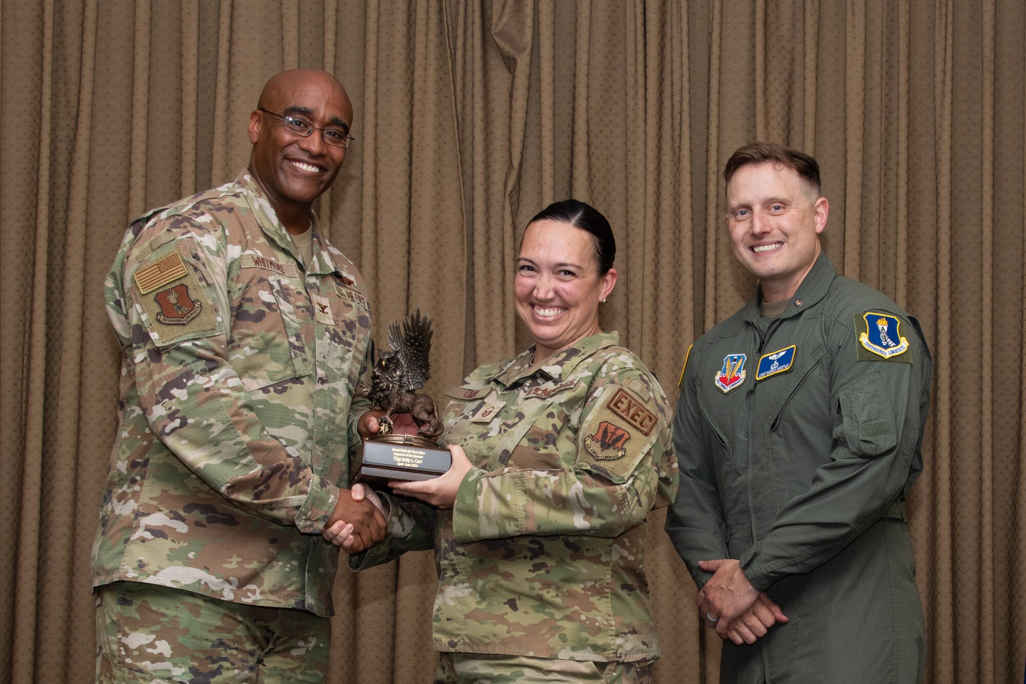 A military member stands on stage to accept an award.