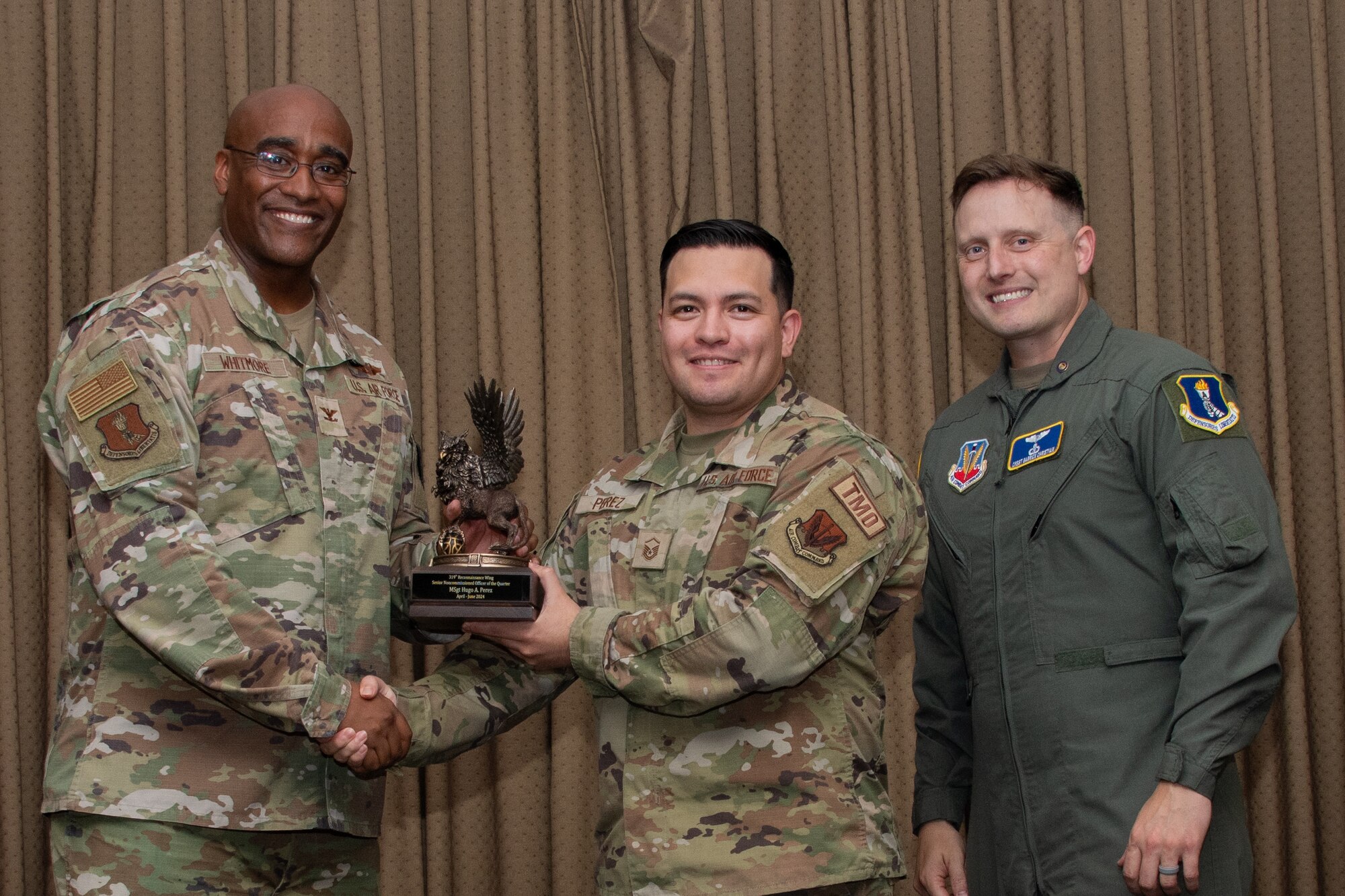 A military member stands on stage to accept an award.