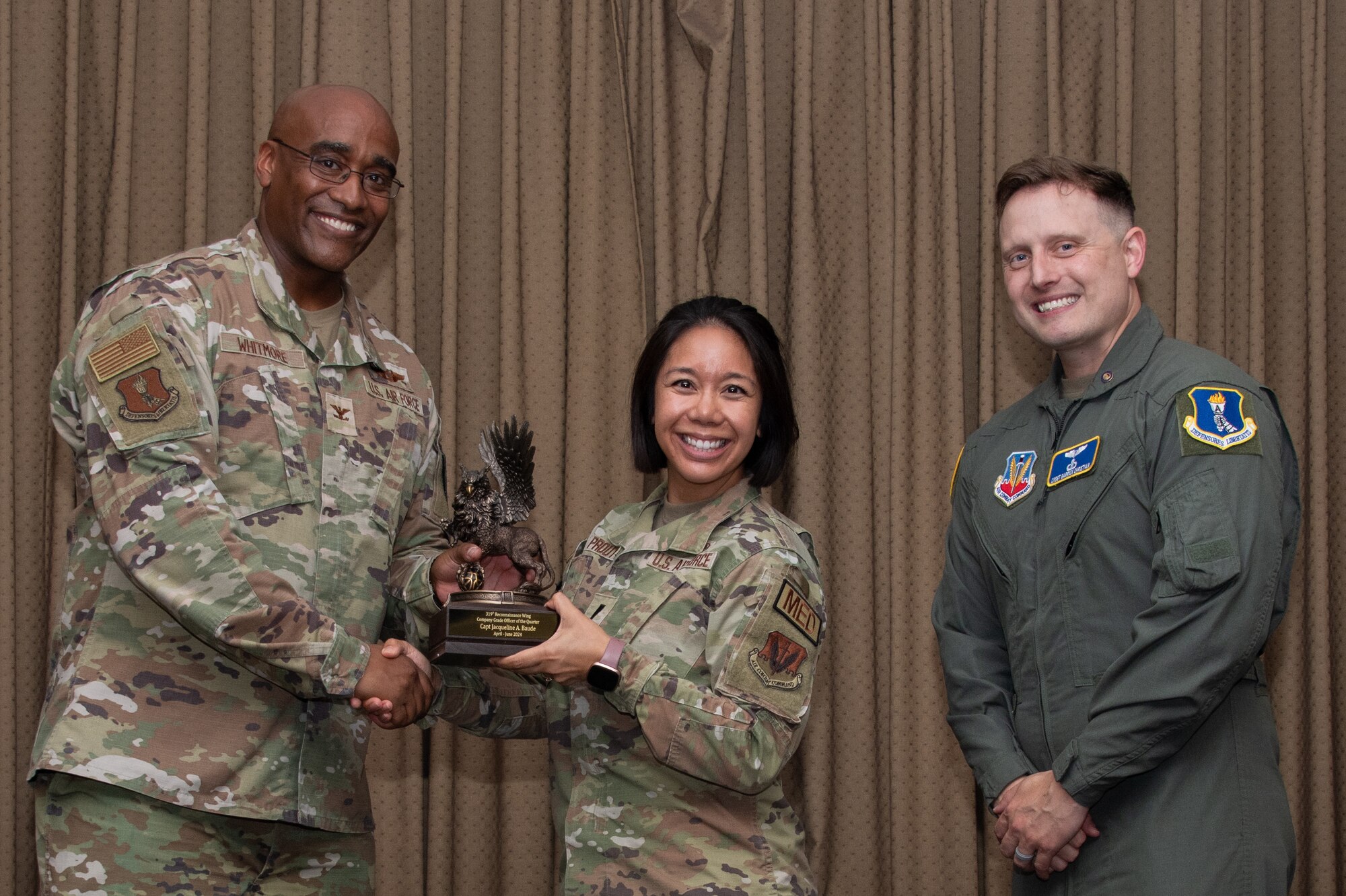 A military member stands on stage to accept an award.