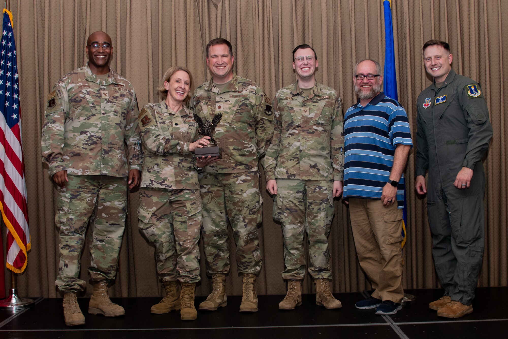 A group of military members stand on stage to accept an award.