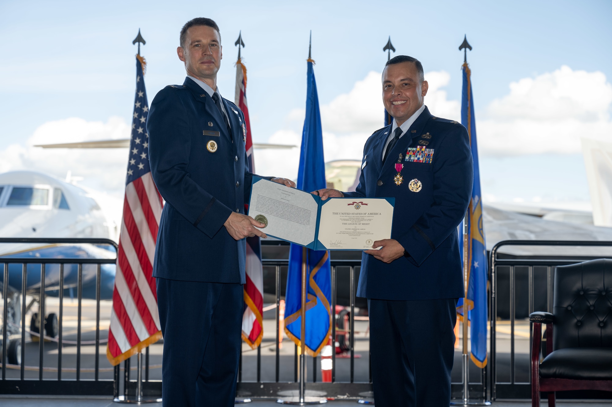 Airmen hold a certificate during a ceremony.