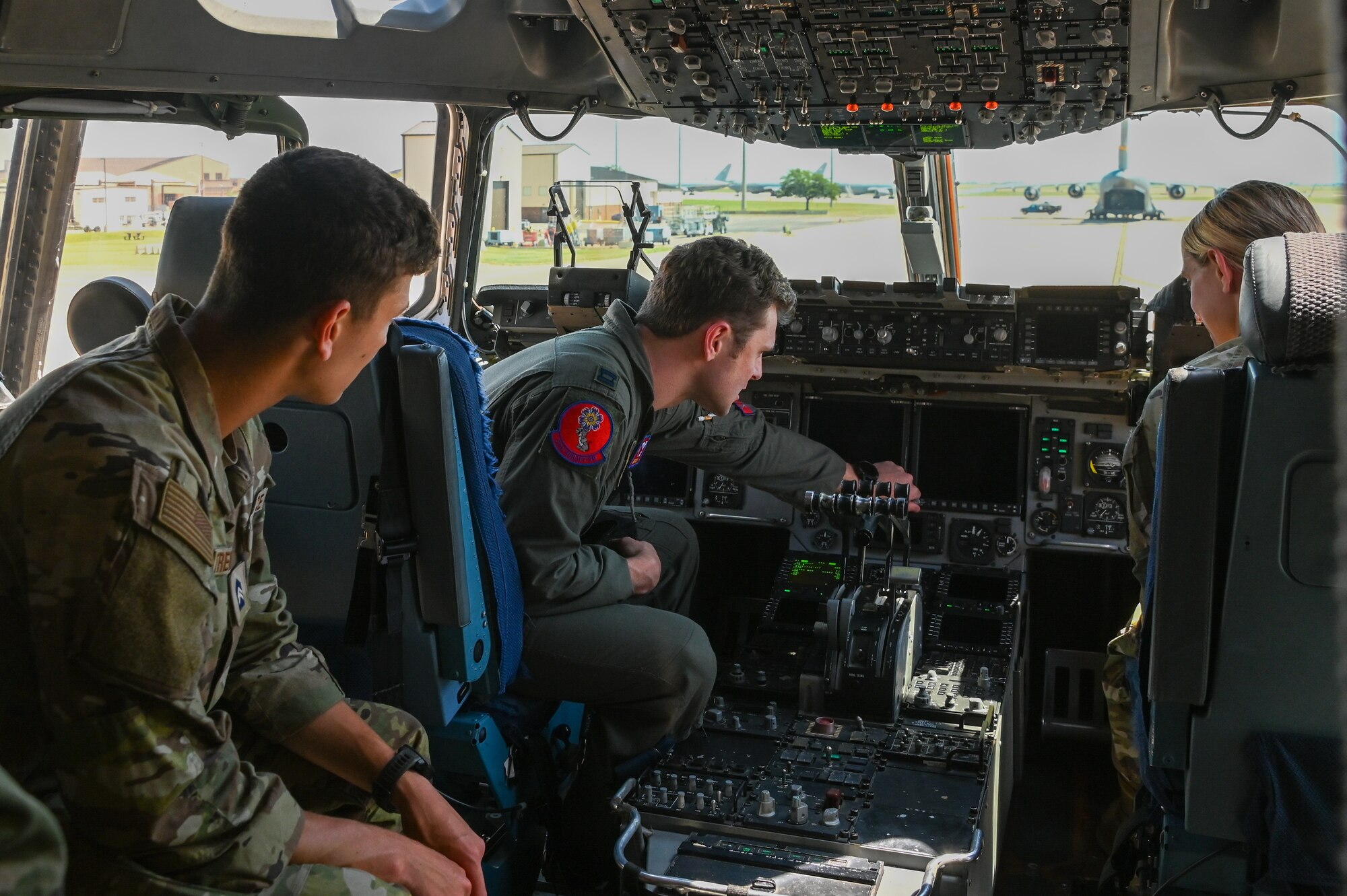 U.S. Air Force Capt. Kevin Foley, 58th Airlift Squadron (AS) instructor pilot, center, shows Francis Treutlein, Virginia Tech Detachment 875 Air Force ROTC (AFROTC) cadet, left, and Caroline Harris, Embry-Riddle Detachment 157 AFROTC cadet, the cockpit of a C-17 Globemaster III aircraft at Altus Air Force Base, Oklahoma, June 24, 2024. During their visit, cadets were given tours of the Office of Special Investigations, Judge Advocates office, and the 58th AS, among other units. (U.S. Air Force photo by Senior Airman Kari Degraffenreed)