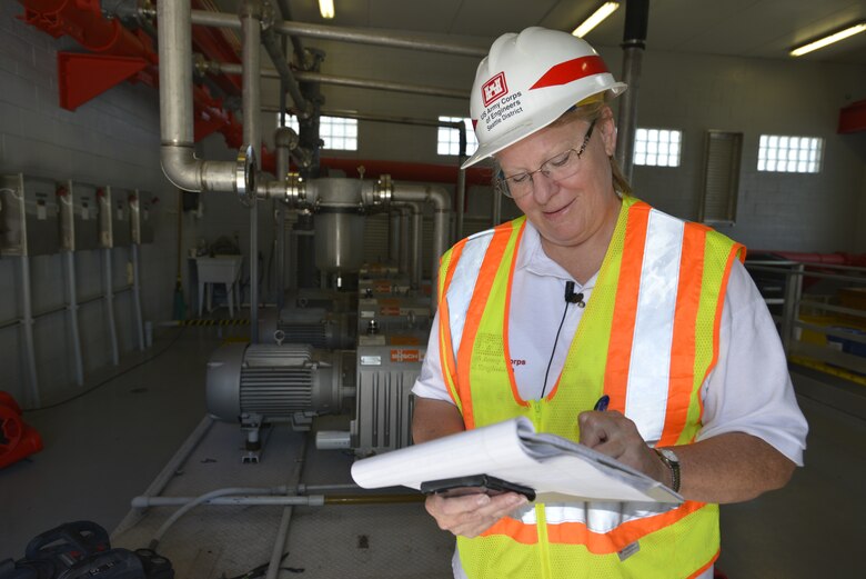 (Left) Cathie Desjardin, a U.S. Army Corps of Engineers emergency operations technician from the Seattle district inspects a vacuum driven collection system in Key Largo, Florida at the Key Largo Waste Water district center.      (USACE Photo by Mark Rankin)
