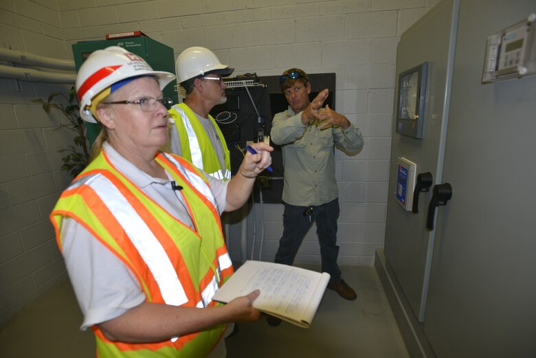 (Left) Cathie Desjardin, a U.S. Army Corps of Engineers emergency operations technician from the Seattle district inspects a vacuum driven collection system in Key Largo, Florida at the Key Largo Waste Water district center as Jared Ryan, (right) Key Largo Wastewater plant manager, describes the functions of the vacuum system that sustained damage to Paul Lad an Environmental Protection Agency environmental scientist.  The pumps service a 16 mile stretch of homes and businesses in the upper Florida Keys.  The Corps and EPA received mission assignments to help assess Water/Wastewater requirements in the Keys, Monroe County, where thousands of homes were severely damaged by Hurricane Irma. (USACE Photo by Mark Rankin)