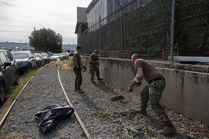 U.S. Marine Corps Lance Cpl. Matthew Willis, left, a motor vehicle operator with Combat Logistics Battalion 23, 4th Marine Logistics Group, pulls weeds alongside U.S. Navy Sailors during a volunteer event at Emerald City Pet Rescue as part of Seattle Seafair Fleet Week in Seattle, Aug. 2, 2024. The U.S. Navy, Coast Guard, and Marines have been involved in Seafair in some way since the festival began 75 years ago. The annual event provides service members an opportunity to interact with the American people and promotes the Navy-Marine Corps team as the nation’s expeditionary force in readiness. Willis is a native of Washington. (U.S. Marine Corps photo by Sgt. Cameron Hermanet)