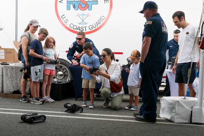 U.S. Coast Guard Damage Controlman 1st Class Noah Weigand, center back, and Boatswain's Mate 1st Class Jesse Wilde, members of the Coast Guard's National Strike Force, demonstrate remotely operated vehicles to visitors at Pier 46 in Seattle during Seattle Seafair Fleet Week Aug. 2, 2024.  Seattle Fleet Week is a time-honored celebration of the sea services and provides an opportunity for the citizens of Washington to meet Sailors, Marines and Coast Guardsmen, as well as witness firsthand the latest capabilities of today’s maritime services. (U.S. Navy photo by Mass Communication Specialist 1st Class Jacob I. Allison)