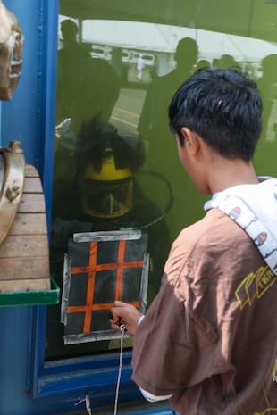 U.S. Navy Diver 2nd Class Mason Barrackman, assigned to the Bangor Dive Locker, plays tic-tac-toe while underwater at Pier 46 in Seattle during Seattle Seafair Fleet Week Aug. 2, 2024.  Seattle Fleet Week is a time-honored celebration of the sea services and provides an opportunity for the citizens of Washington to meet Sailors, Marines and Coast Guardsmen, as well as witness firsthand the latest capabilities of today’s maritime services. (U.S. Navy photo by Mass Communication Specialist 1st Class Jacob I. Allison)